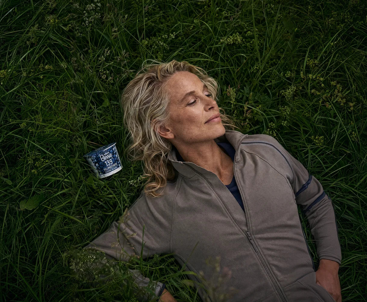 Woman lying in grass with Roberts Berrie cup
